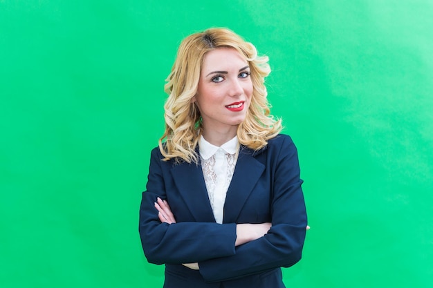 Portrait of businesswoman standing against green background