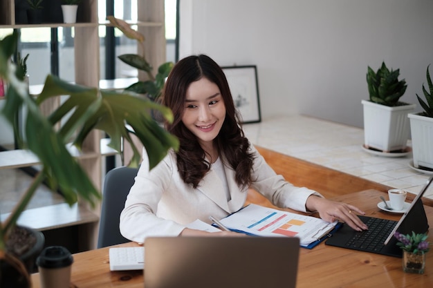 Portrait of Busy Asian Secretary smiling and waiting customer while working at office. Business Finance concept.