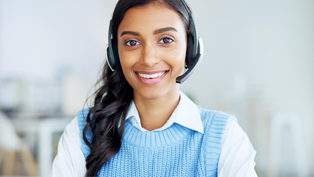 Portrait of a call center agent using a headset while consulting for customer service and sales support Confident young businesswoman smiling while operating a helpdesk and looking confident