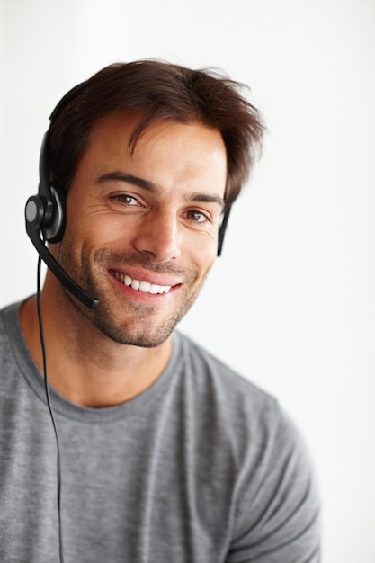 Portrait call center and happy man isolated on a white background in virtual communication or technical support Face of business agent consultant or sales person for telemarketing career in studio