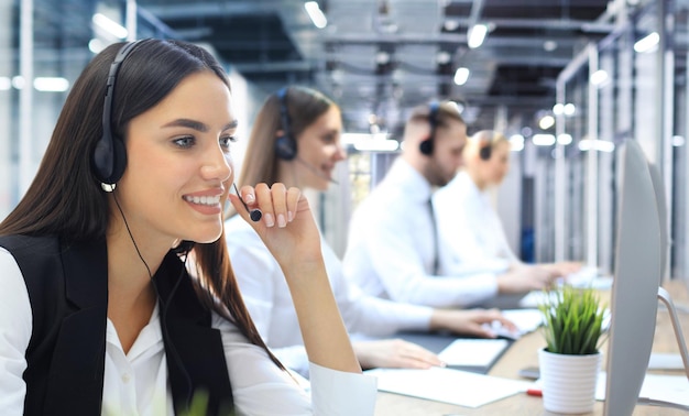 Portrait of call center worker accompanied by his team Smiling customer support operator at work