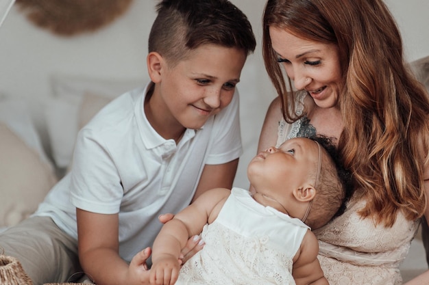 Portrait of candid friendly happy interracial family with two kids spending time together at home