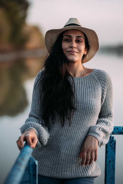 Portrait of a candid woman looking at the camera in a fashionable hat Vertical