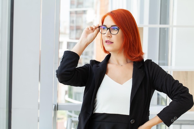 Portrait of a casual businesswoman with short red hair in a modern house