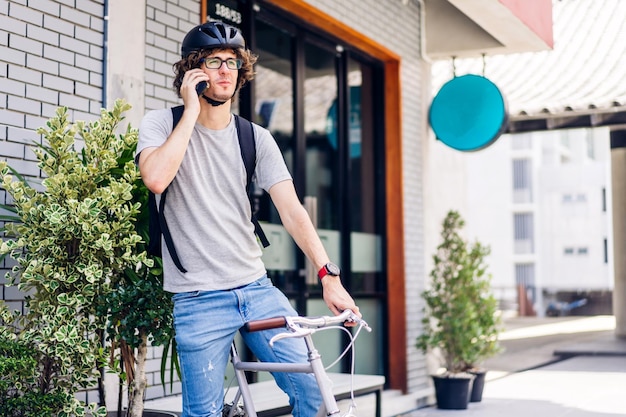 Portrait of casual hipster handsome businessman with backpack looking forward while commuting riding bicycle on the street city way go to workbusiness travel transport bike concept