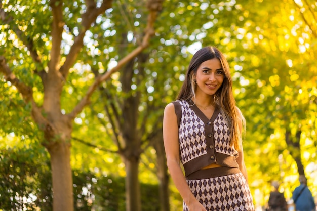 Portrait of a caucasian brunette woman in autumn in a natural city park autumn lifestyle