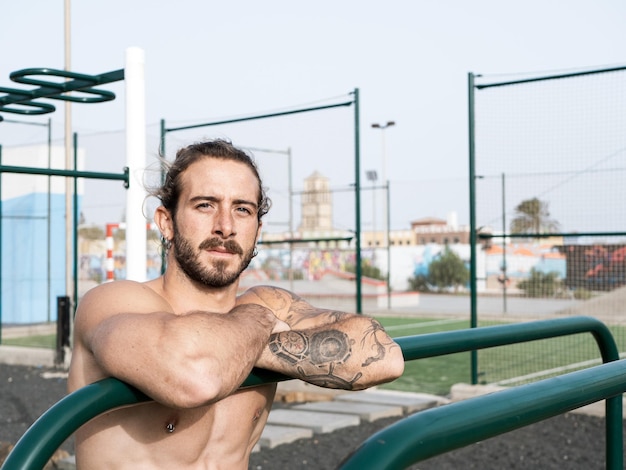 Portrait of a caucasian calisthenics athlete outdoor at the calisthenics park