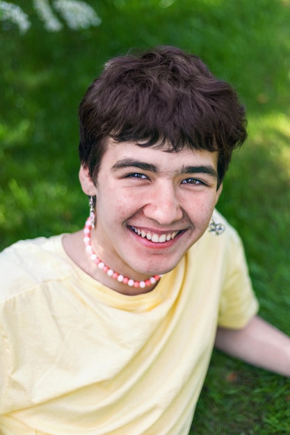 Portrait of Caucasian cheerful young man with earrings in his ears