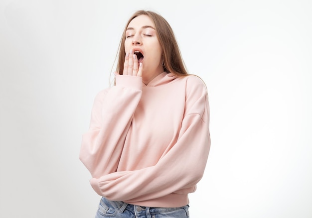 Portrait of Caucasian yawning woman isolated on white background I want to sleep