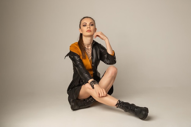 Portrait of caucasian young attractive woman posing on a white floor in white studio. Model tests of pretty girl on cyclorama.