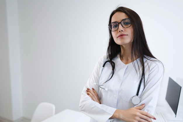 Portrait of caucasian young female medical worker in clinic with arm crossed