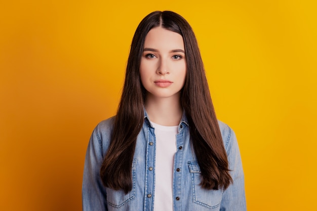 Portrait of charming adorable young girl on yellow background