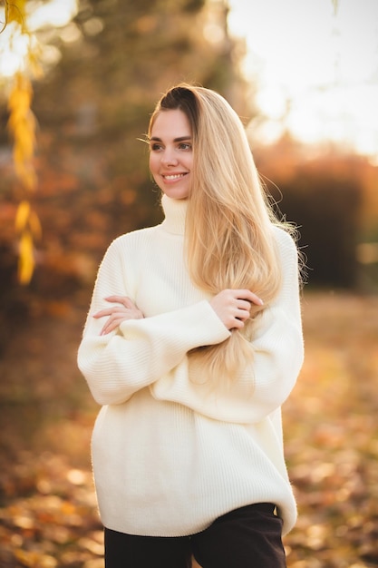 Portrait of a charming blonde with a gorgeous smile A girl in a white sweater relaxes