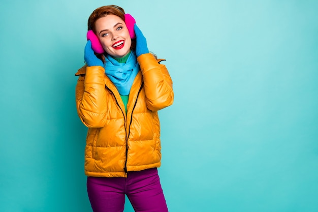 Photo portrait of charming cute woman rest relax touch soft bright ear muffs enjoy wear casual style blue trousers pink yellow clothes.