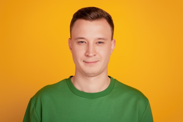 Portrait of charming handsome guy look camera posing on yellow background