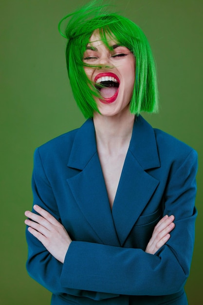 Portrait of a charming lady wearing a green wig blue jacket posing green background unaltered