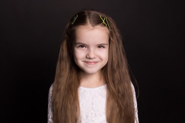 Portrait of a charming little girl, isolated on a black background