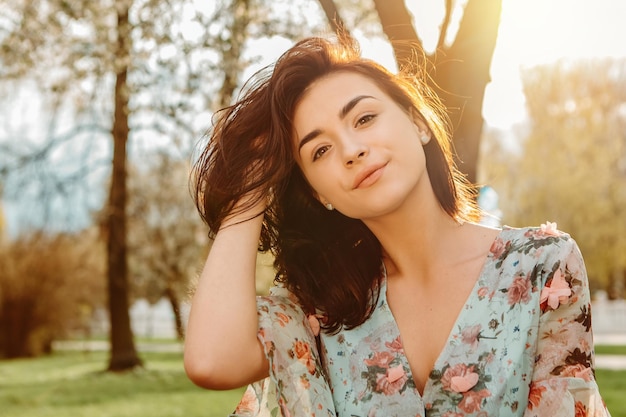 Portrait of charming woman posing near apple cherry tree blossoms blooming flowers in the garden