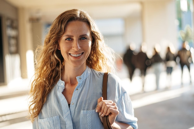 Portrait of a charming young woman posing for camera in the city