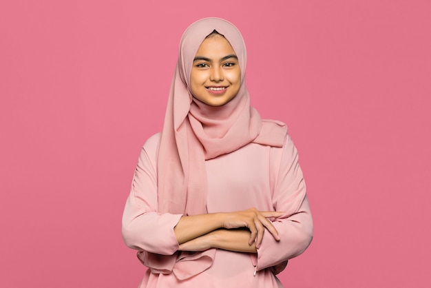 Portrait of cheerful attractive Asian woman with arms crossed and smiling