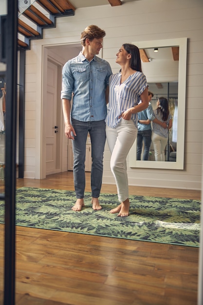 portrait cheerful beautiful couple standing in living room while looking to each other