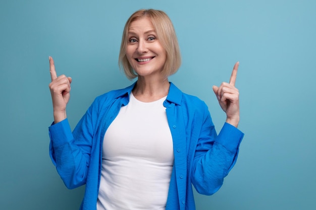 Portrait of cheerful blonde s woman in casual stylish shirt with crossed arms on studio background