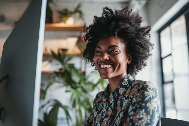 Portrait of a cheerful business African American woman working on a laptop in a large office