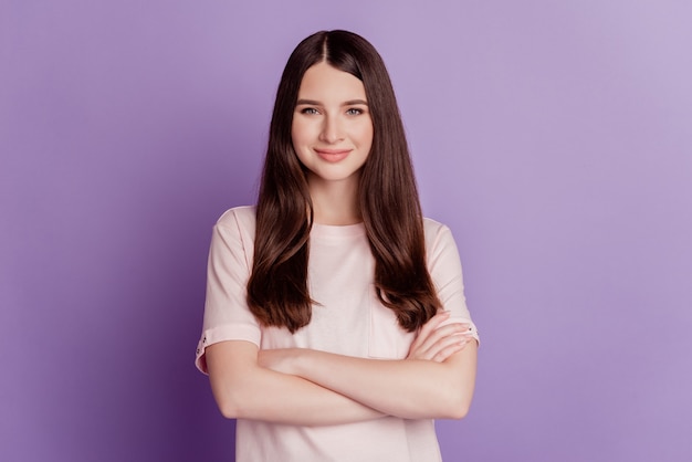 Portrait of cheerful business woman crossed hands isolated on purple background