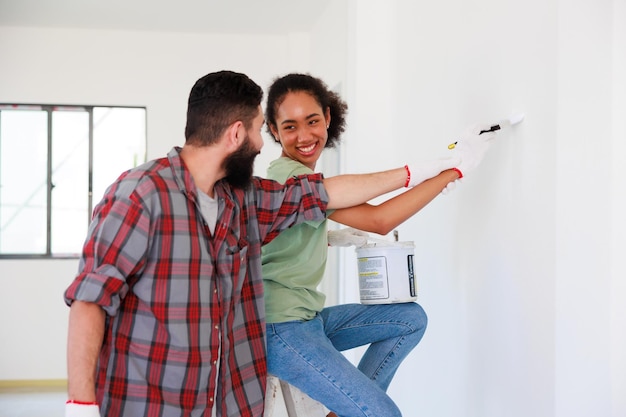 Portrait Cheerful couple young man and black woman smiling during renovation in new apartment Young happy family renovating house and planning bed room