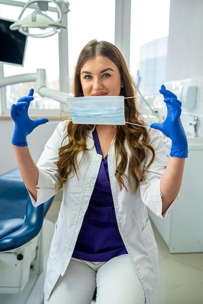 Portrait of cheerful female dentist in uniform looking at camera at modern clinic healthcare alone