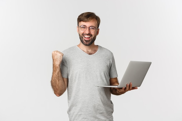 Portrait of cheerful handsome guy in glasses and gray t-shirt