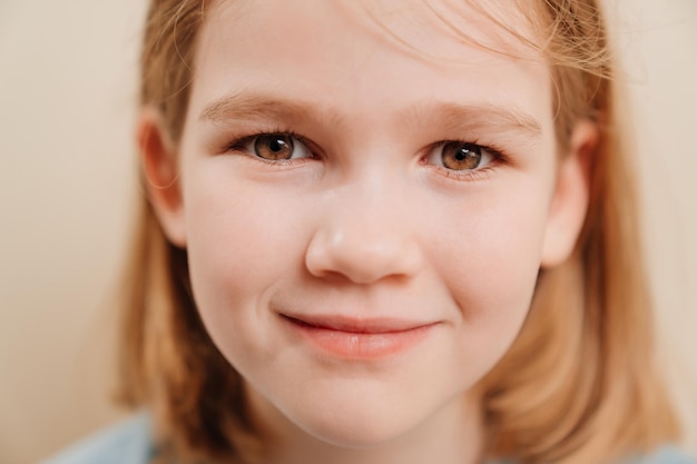 Portrait of a cheerful little girl with blonde hair in a blue Tshirt