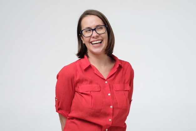 Portrait of cheerful mature woman in glasses laughing on joke