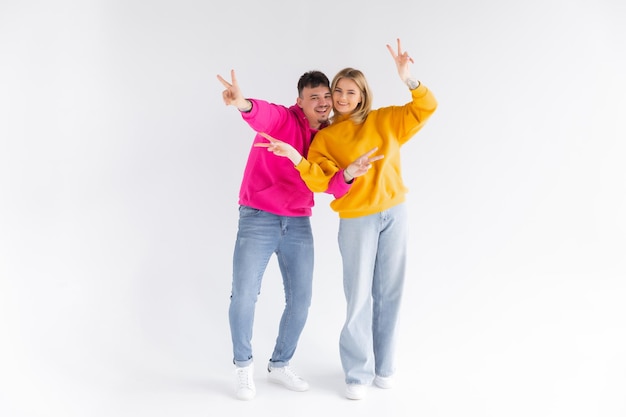 Portrait of cheerful people man and woman in basic clothing smiling and clenching fists like winners