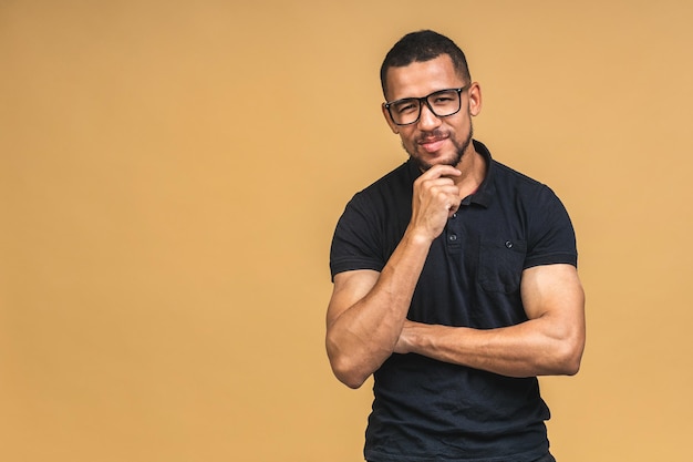 Portrait of a cheerful smiling young african american black man standing isolated over beige background