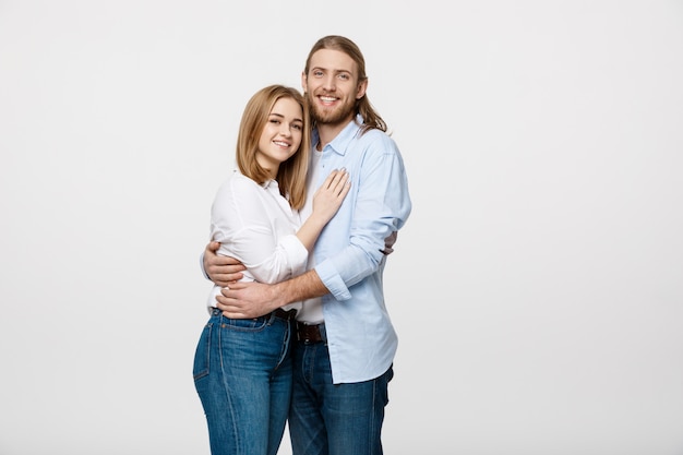 Portrait of cheerful young couple standing and hugging each other