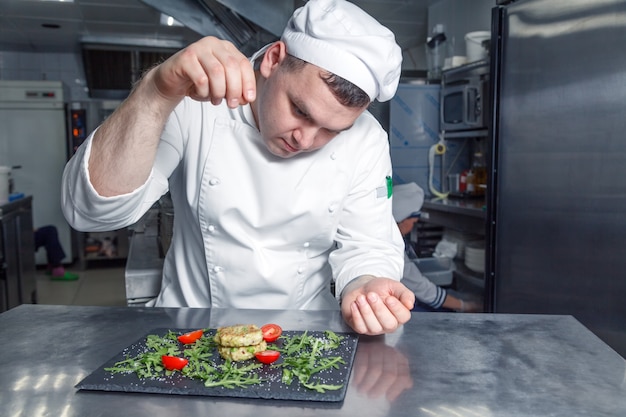 Portrait of chef in restaurant kitchen cooking