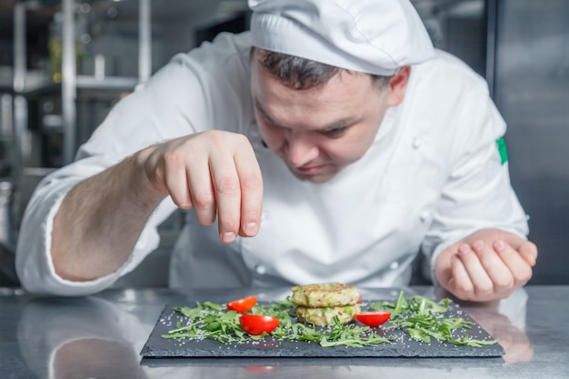 Portrait of chef in restaurant kitchen cooking