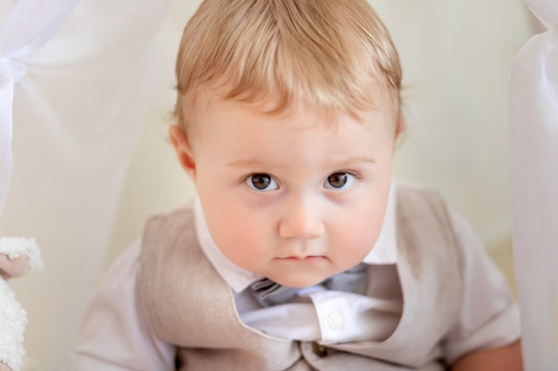 Portrait of a child 1 year old boy in a suit and a bow tie