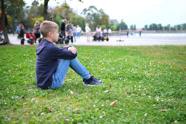 Portrait of child boy outdoors resting on grass lawn