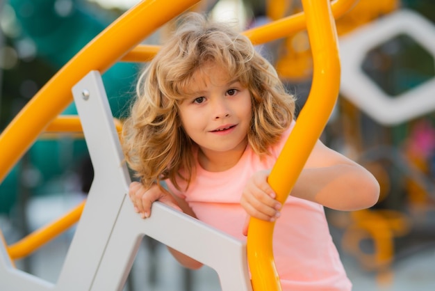 Portrait of child doing rock climbing with background playground