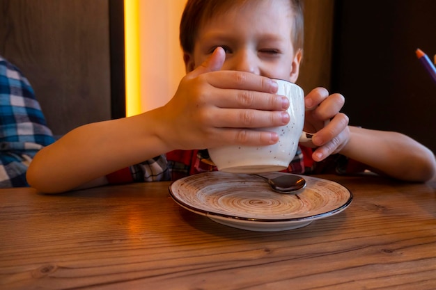 Portrait of child drinking tea in cafe