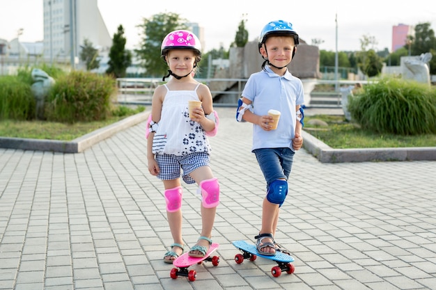 Portrait of children in the park with skates, they eat ice cream