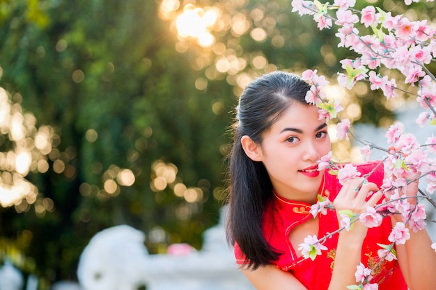 Portrait chinese woman red dress traditional cheongsam in chinese temple.