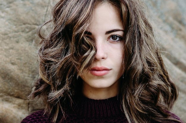 Portrait close up of young beautiful woman outdoorsthe hair covers half of the face