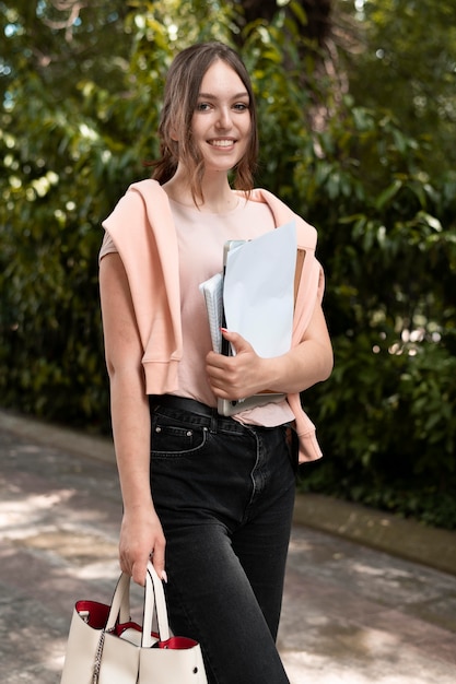 Portrait of college student holding some books