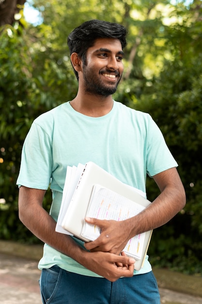 Portrait of college student holding some books