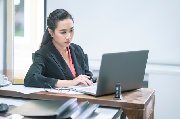 Portrait of comfident young  entrepreneur businesswoman working with tablet or mobile device in working station.