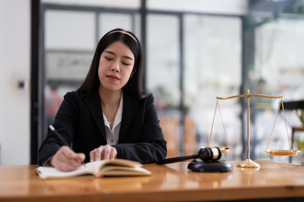 Portrait confidence asian lawyer taking note sitting at work desk in office