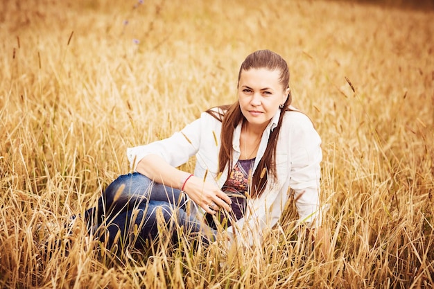 Portrait of a confident authentic woman sitting in a field in the countryside